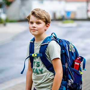 young male student with blue backpack